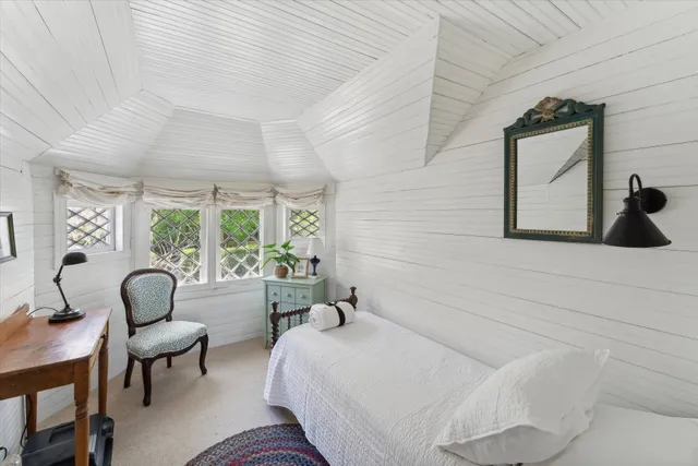 a bedroom with a bed and a large window