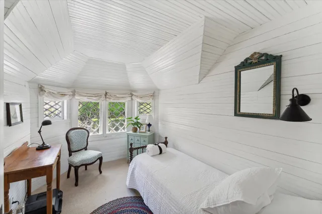 a bedroom with furniture and a large window