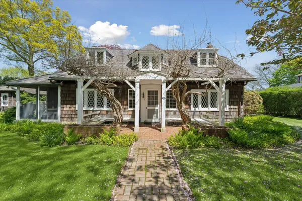a front view of a house with a garden and plants