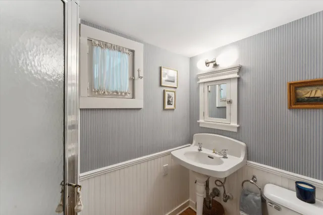 a bathroom with a sink a toilet and a mirror