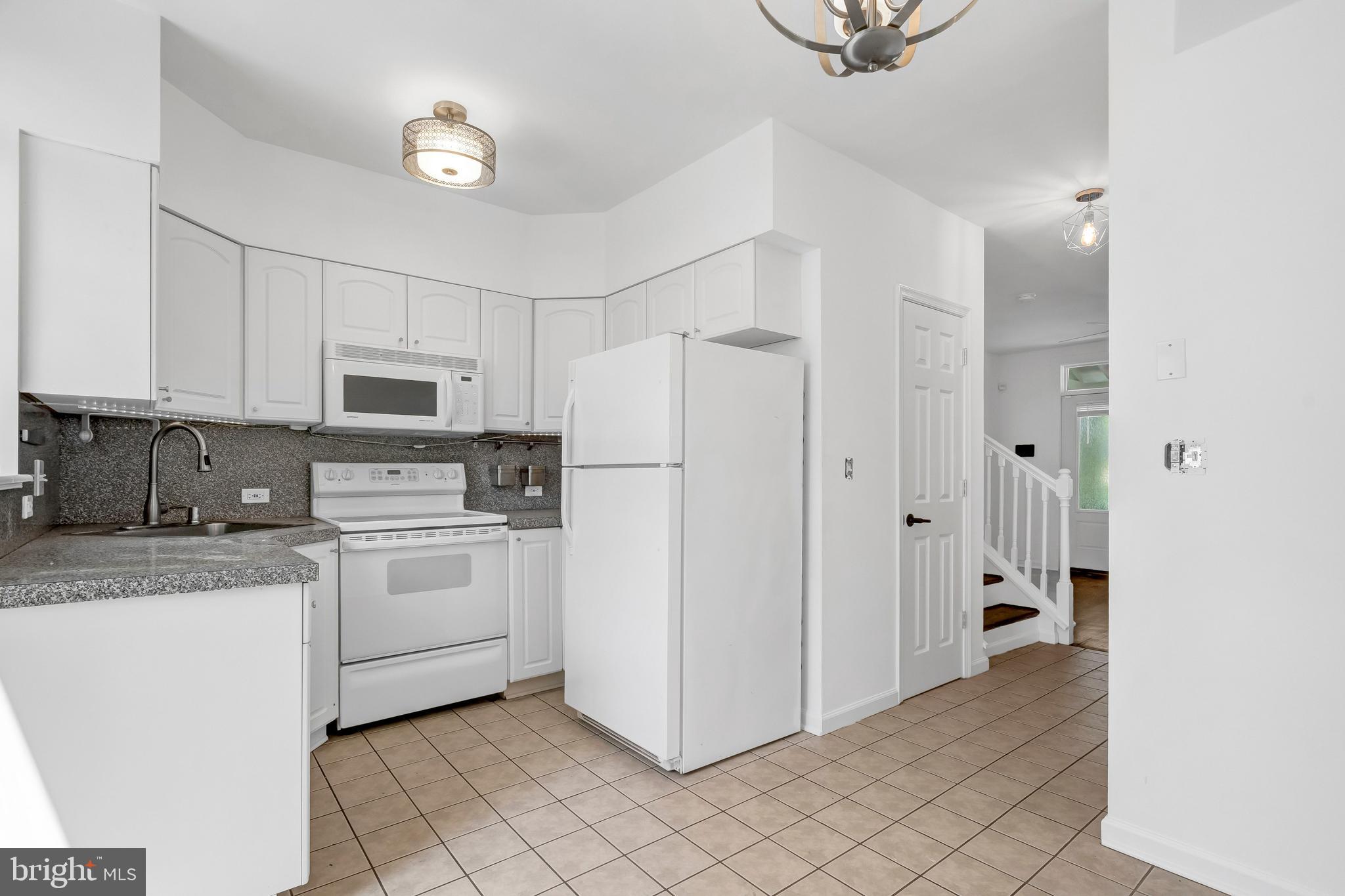 1749 L Street Northeast Washington, DC 20002 - Photo 7 of 24 a kitchen with white cabinets and white appliances