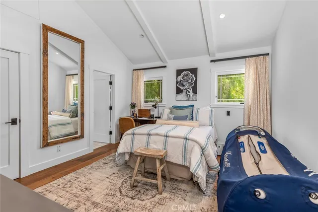 a bedroom with a bed a computer on desk and a large window