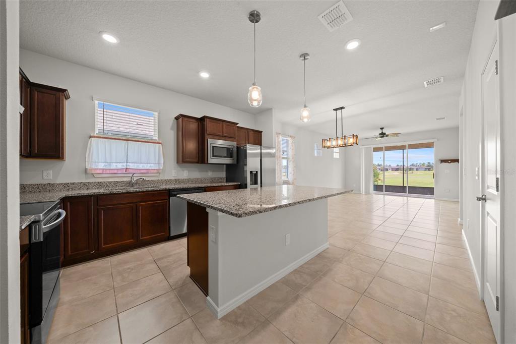5947 Southwest 93rd Circle Ocala, FL 34481 - Photo 10 of 32 a large kitchen with granite countertop a large counter top stainless steel appliances and cabinets