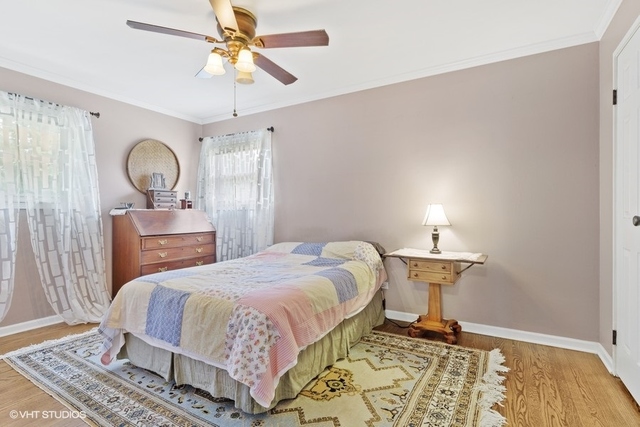 455 Elmhurst Road Mount Prospect, IL 60056 - Photo 13 of 19 a bedroom with a bed and a table lamp