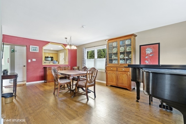 455 Elmhurst Road Mount Prospect, IL 60056 - Photo 3 of 19 a dining room with furniture a floor to ceiling window and wooden floor