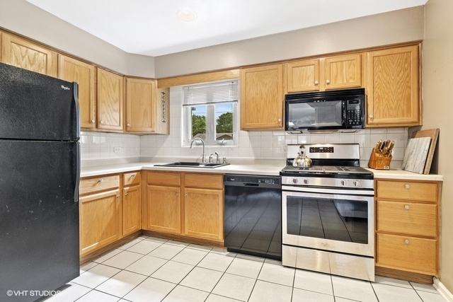 455 Elmhurst Road Mount Prospect, IL 60056 - Photo 6 of 19 a kitchen with granite countertop a stove top oven microwave and cabinets
