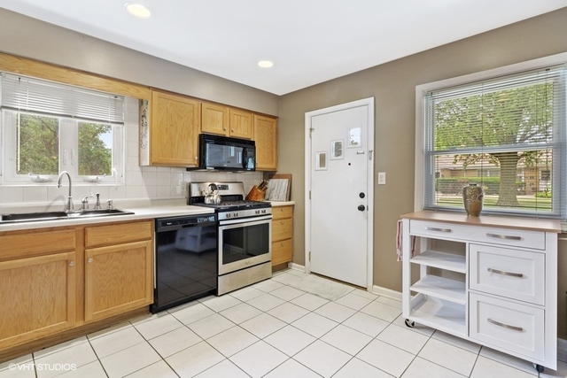 455 Elmhurst Road Mount Prospect, IL 60056 - Photo 7 of 19 a kitchen with granite countertop a stove top oven sink and cabinets
