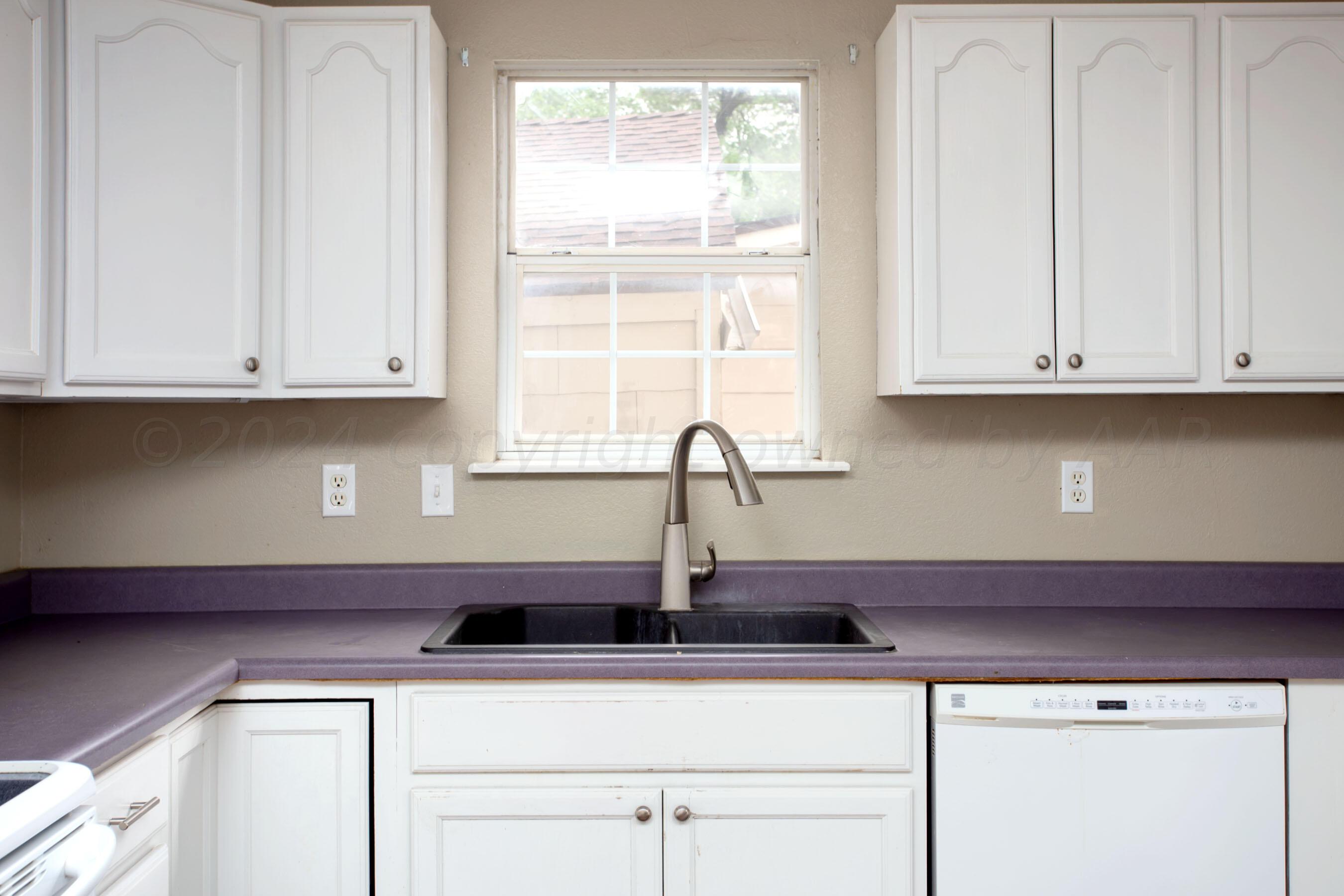 4205 South Ong Street Amarillo, TX 79110 - Photo 11 of 25 a kitchen with appliances cabinets and a window