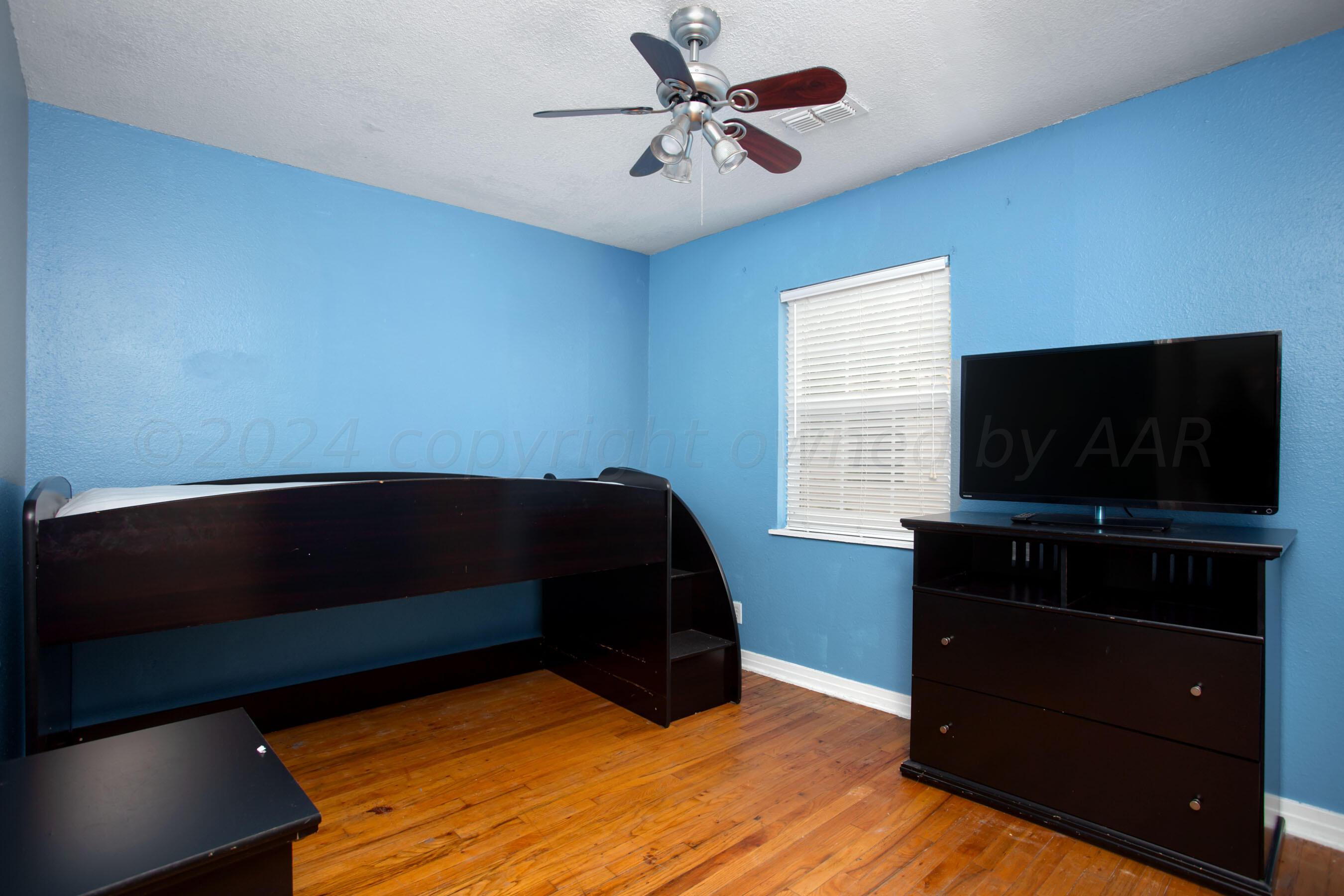 4205 South Ong Street Amarillo, TX 79110 - Photo 19 of 25 a bedroom with a bed and a flat screen tv