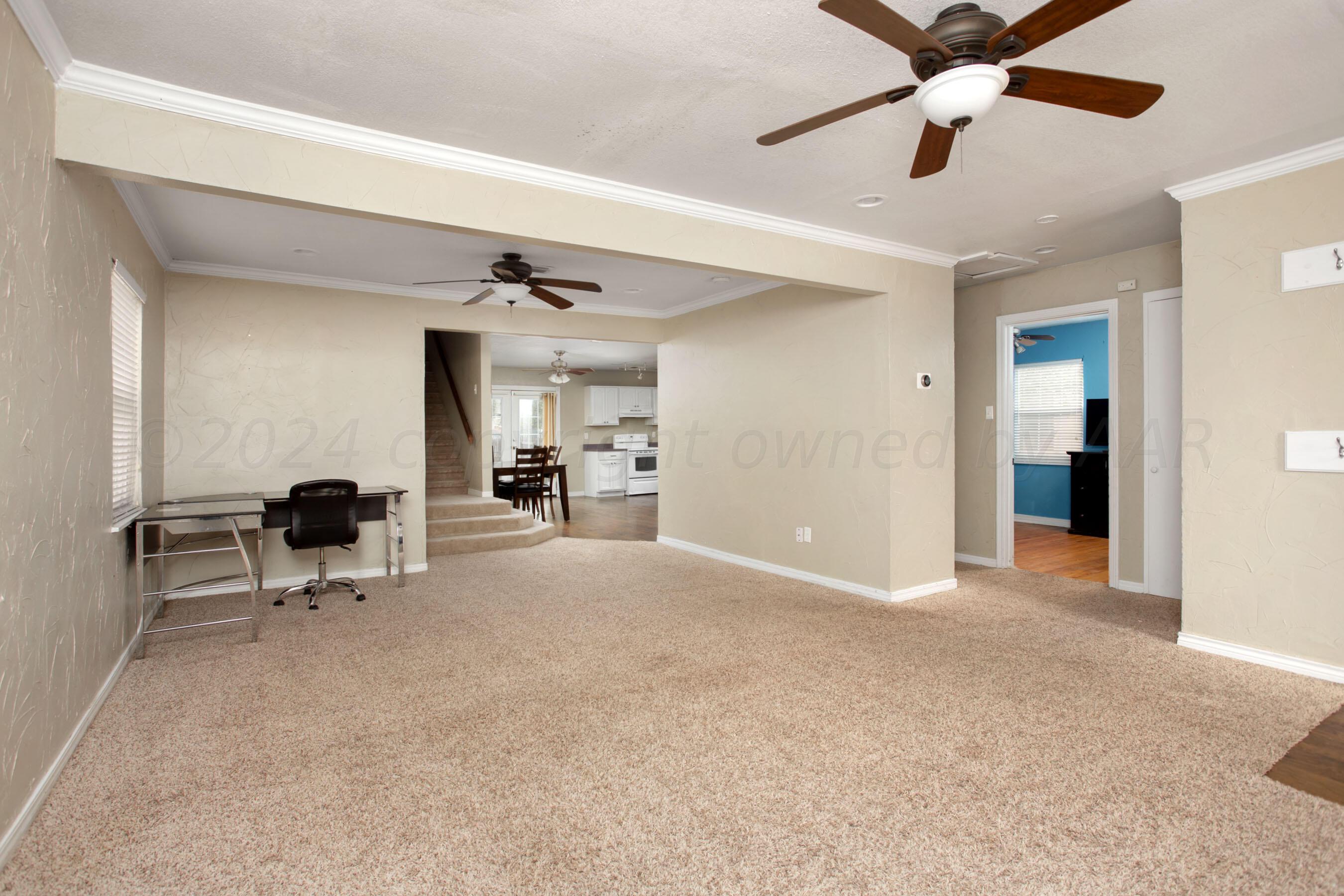 4205 South Ong Street Amarillo, TX 79110 - Photo 6 of 25 a view of a livingroom with a flat screen tv wooden floor and a ceiling fan
