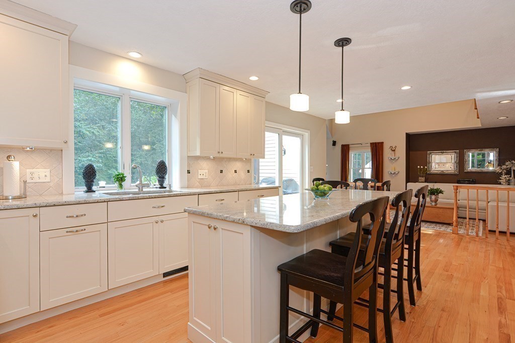 75 Alpine Drive Holliston, MA 01746 - Photo 13 of 42 a large kitchen with granite countertop a stove a sink a dining table and chairs