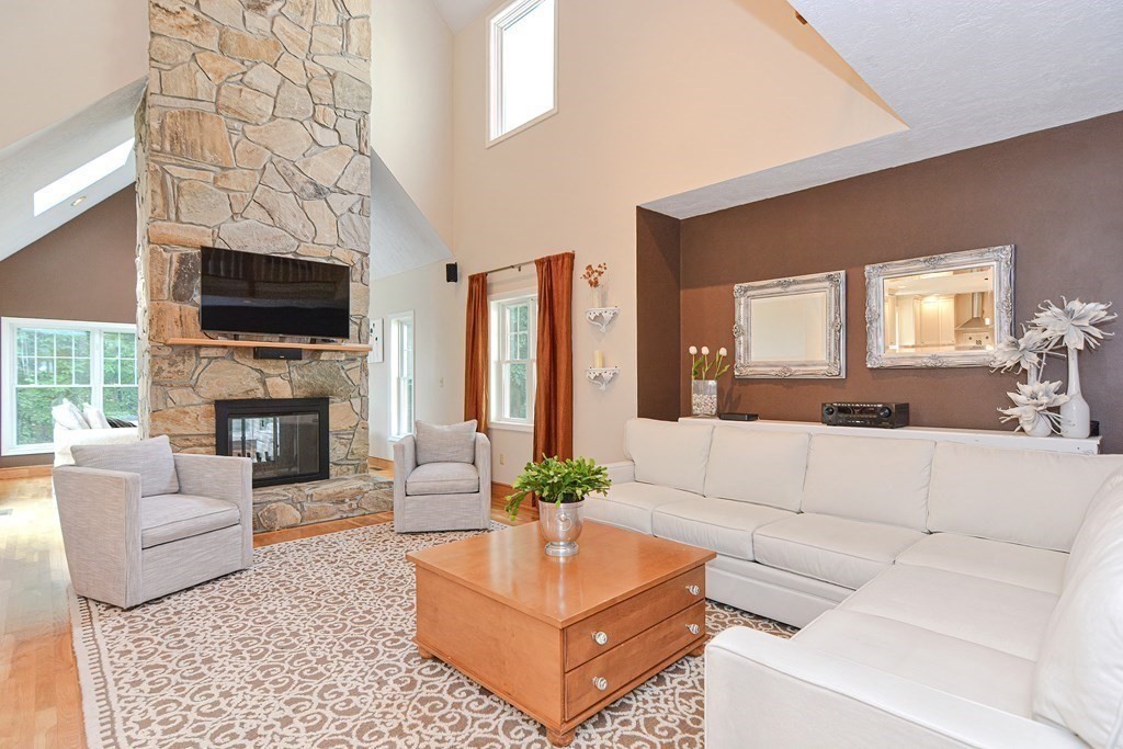 75 Alpine Drive Holliston, MA 01746 - Photo 16 of 42 a living room with furniture a fireplace and a flat screen tv