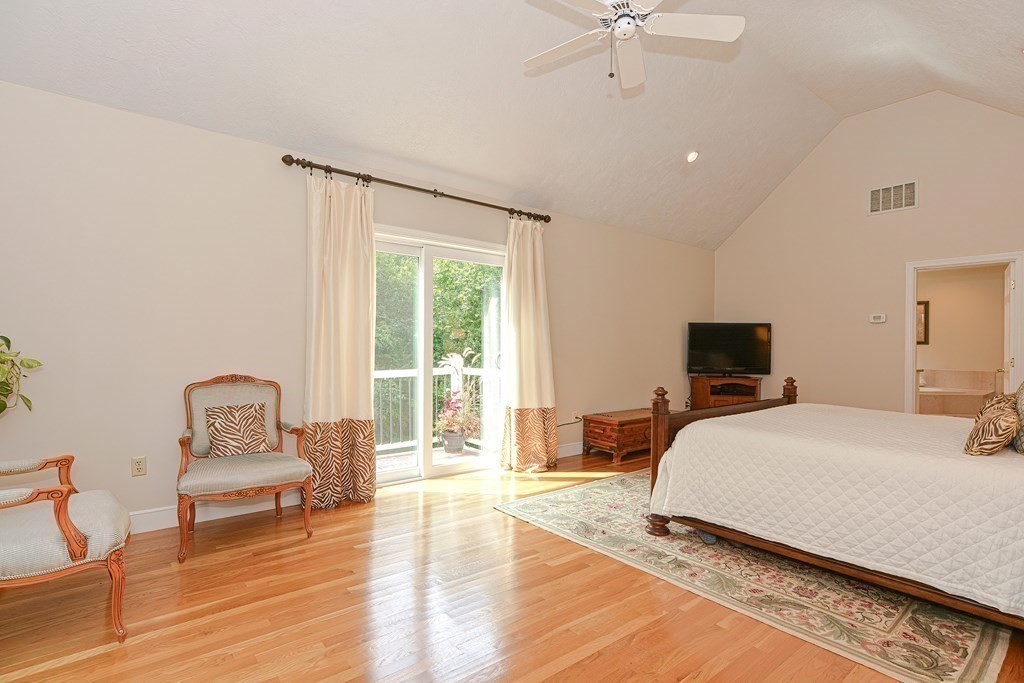 75 Alpine Drive Holliston, MA 01746 - Photo 26 of 42 a bedroom with a bed a couch and a chandelier