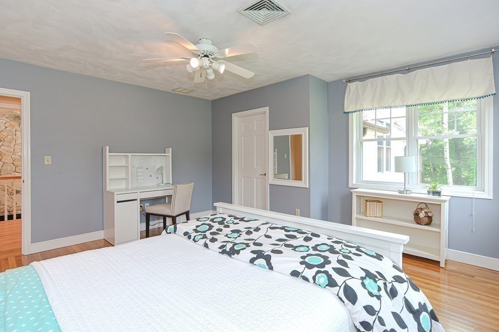 75 Alpine Drive Holliston, MA 01746 - Photo 31 of 42 a bedroom with a large bed and a chandelier