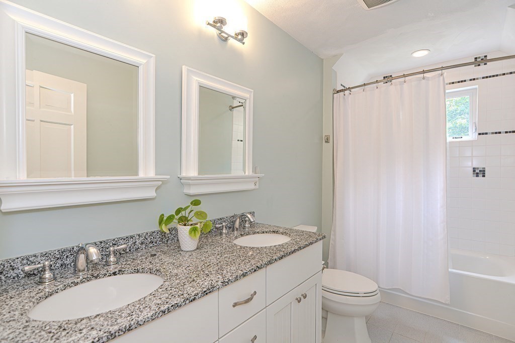 75 Alpine Drive Holliston, MA 01746 - Photo 36 of 42 a bathroom with a granite countertop sink a toilet and a mirror