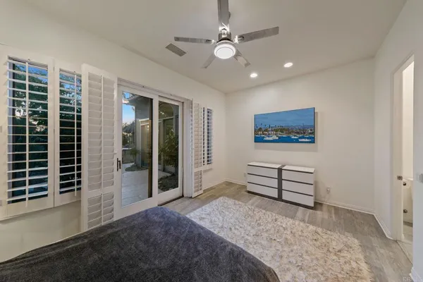 a spacious bedroom with a bed and a flat screen tv