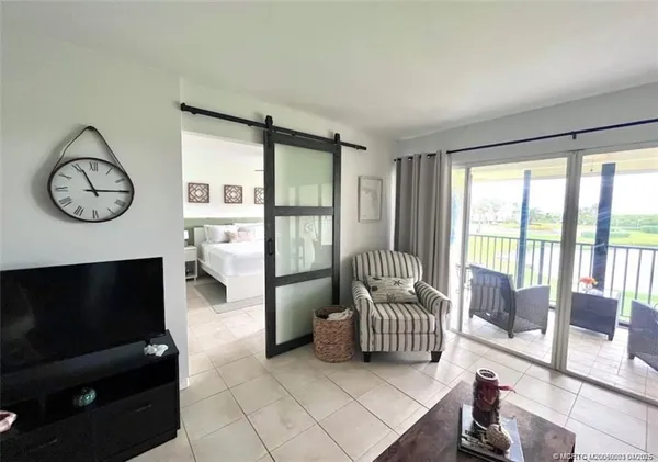a living room with furniture a flat screen tv and a large window
