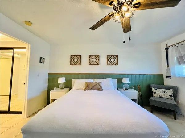 a bedroom with a bed and ceiling fan