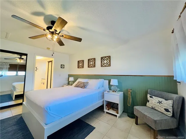 a bedroom with a bed couch and a ceiling fan