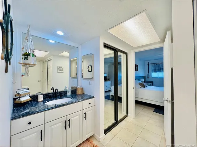 a spacious bathroom with a granite countertop sink a mirror and shower