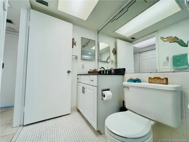 a bathroom with a granite countertop toilet sink and mirror