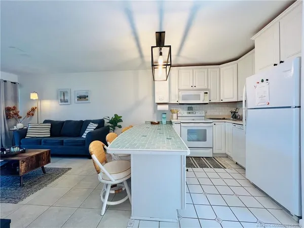 a kitchen with granite countertop a sink appliances a counter space and cabinets