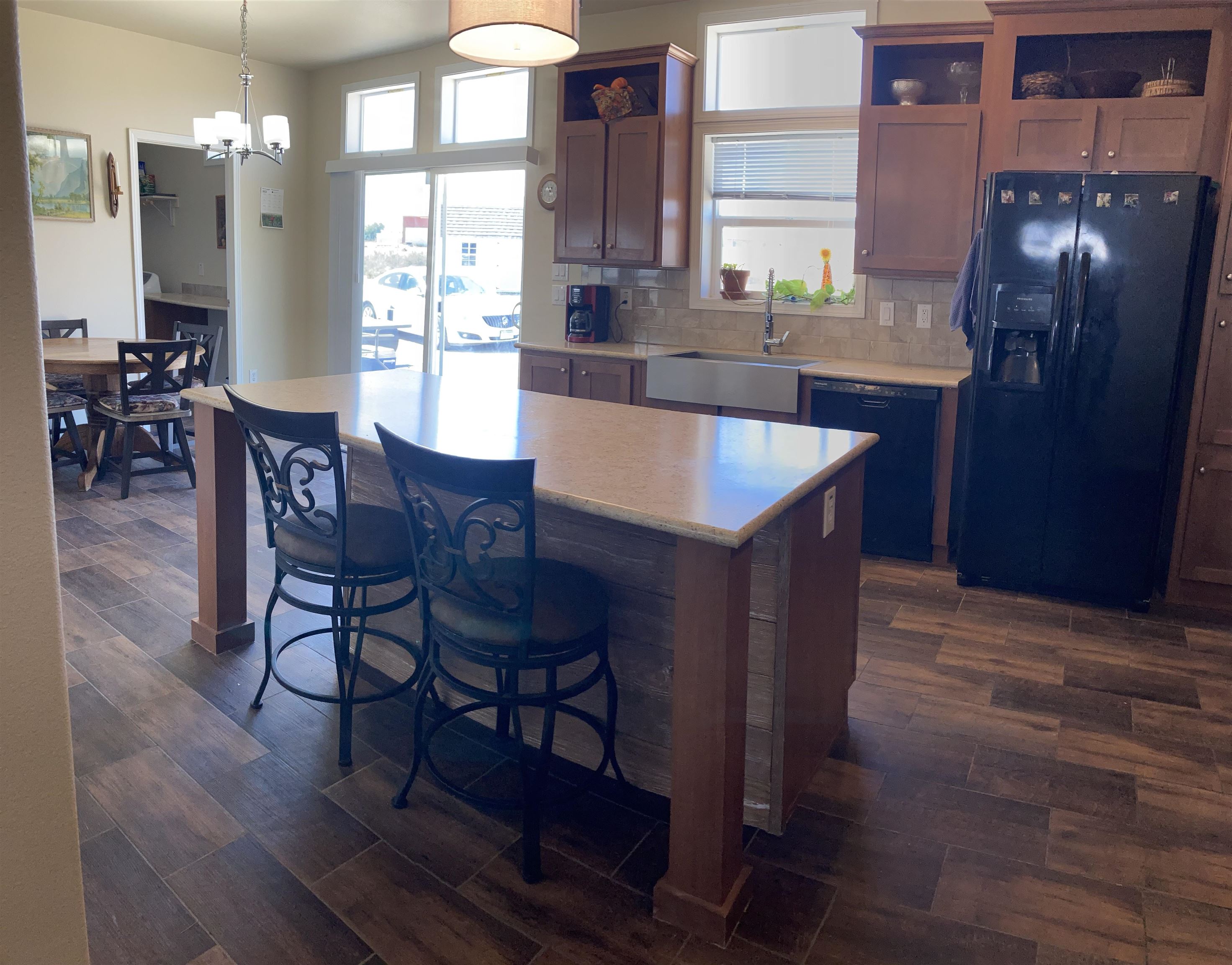 2413 1300th Road Delta, CO 81416 - Photo 10 of 35 a kitchen with stainless steel appliances granite countertop a table chairs and a refrigerator