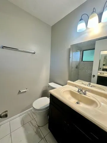 a bathroom with a sink a toilet a mirror and vanity