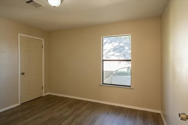 an empty room with wooden floor and a window