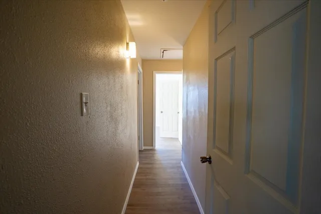 an empty room with wooden floor ceiling fan and windows