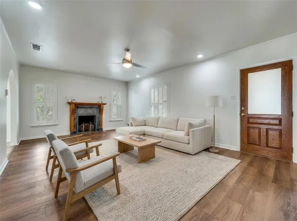a living room with furniture a fireplace and a wooden floor