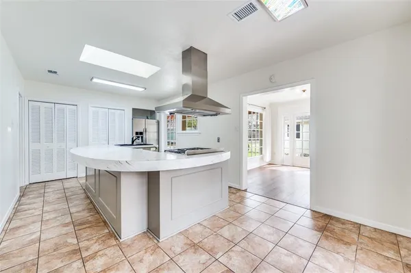 a large kitchen with kitchen island a sink stainless steel appliances and cabinets