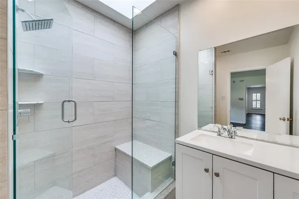 a bathroom with a shower sink and mirror