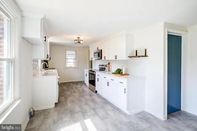 a kitchen with cabinets a sink and white appliances
