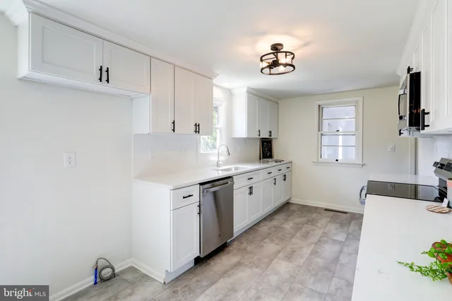 a kitchen with granite countertop a sink stainless steel appliances and cabinets