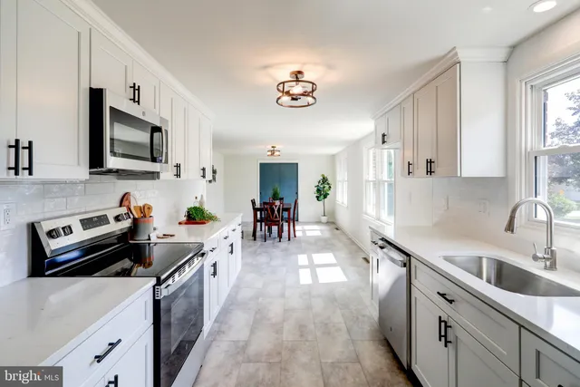 a kitchen with stainless steel appliances a sink cabinets and wooden floor