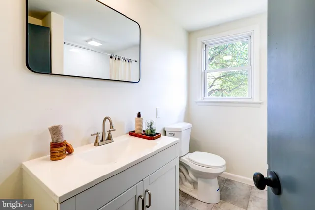 a bathroom with a sink a toilet and mirror