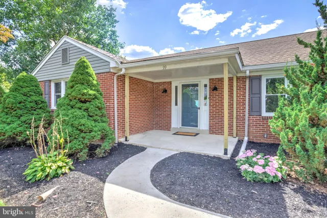 a view of a yard in front of a house with large tree