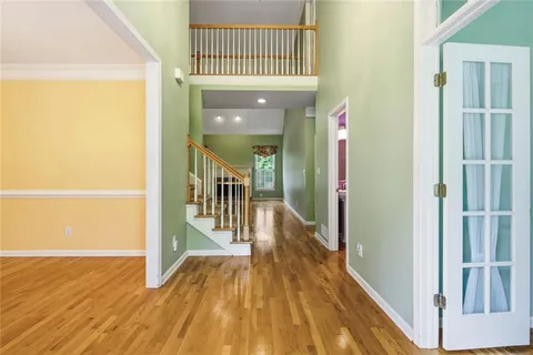 a view of a hallway with wooden floor and staircase