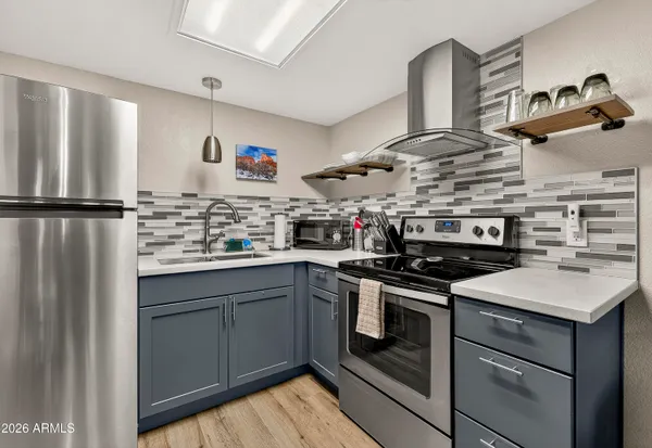 a kitchen with stainless steel appliances granite countertop a sink stove and refrigerator