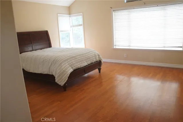 a bedroom with a bed and wooden floor