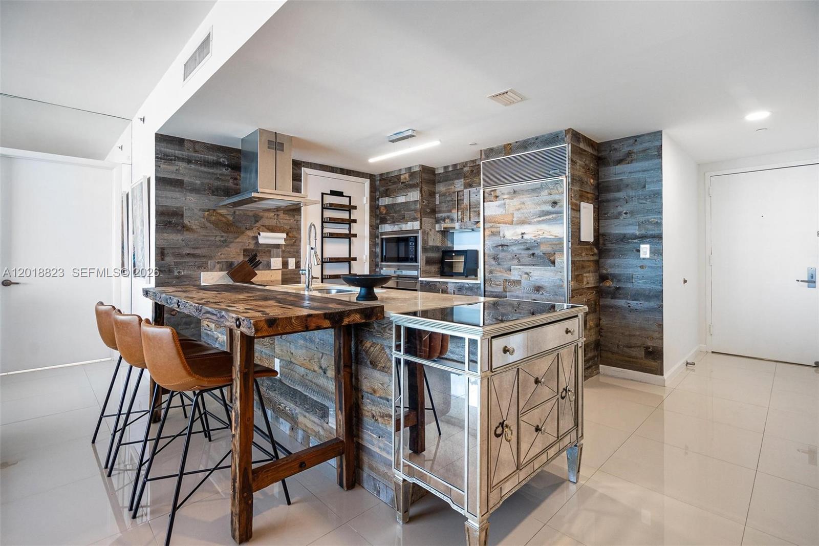495 Brickell Avenue, Unit 4911 Miami, FL 33131 - Photo 7 of 35 a kitchen with stainless steel appliances kitchen island granite countertop a table chairs in it and wooden floors