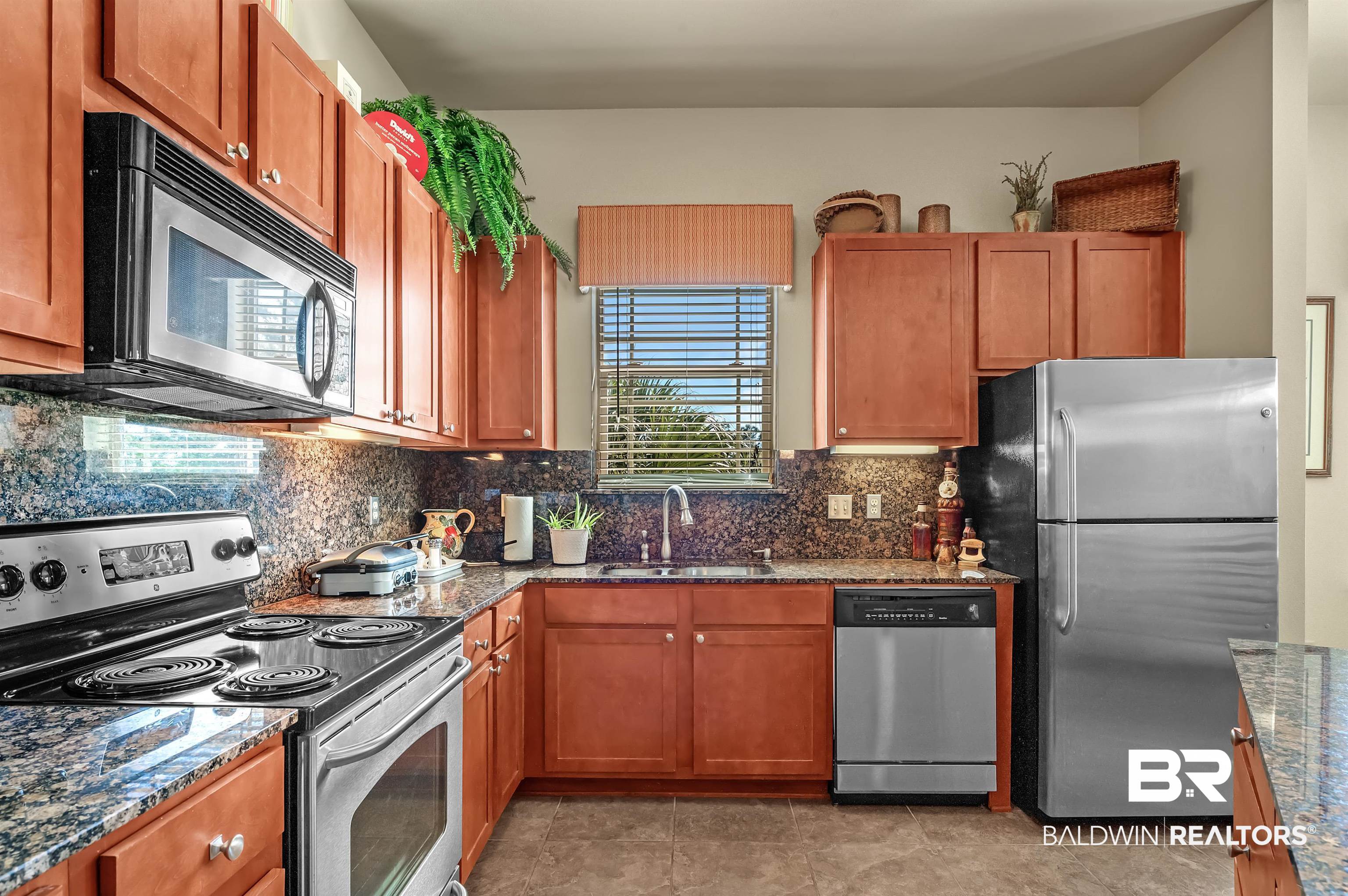 1430 Regency Road, Unit A301 Gulf Shores, AL 36542 - Photo 13 of 47 Kitchen featuring dark stone countertops, stainless steel appliances, tasteful backsplash, and sink