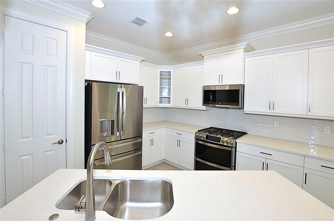 6145 Bella Rosa Lane Vero Beach, FL 32966 - Photo 12 of 36 a kitchen with granite countertop a refrigerator stove and microwave