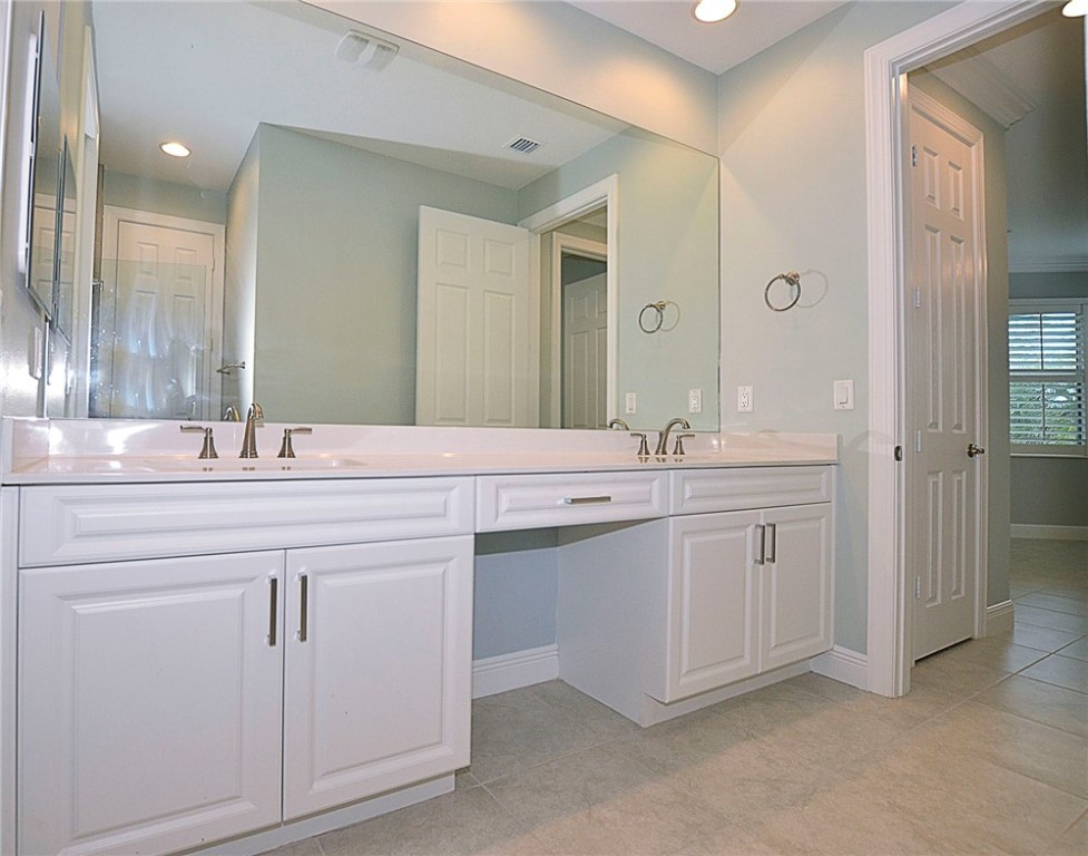 6145 Bella Rosa Lane Vero Beach, FL 32966 - Photo 18 of 36 a bathroom with double sink and a mirror