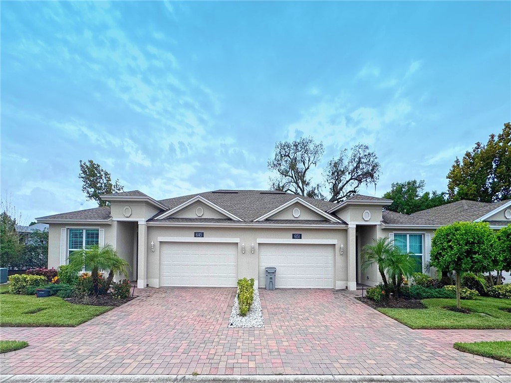 6145 Bella Rosa Lane Vero Beach, FL 32966 - Photo 2 of 36 a front view of a house with a yard and garage