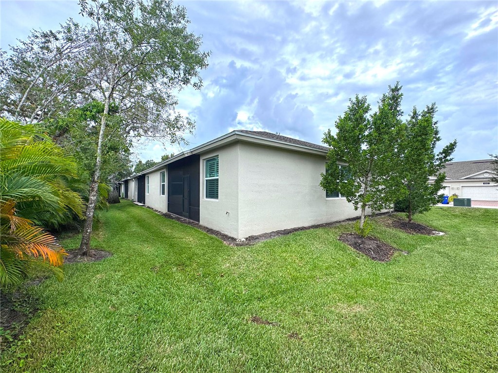 6145 Bella Rosa Lane Vero Beach, FL 32966 - Photo 30 of 36 a backyard of a house with plants and large tree