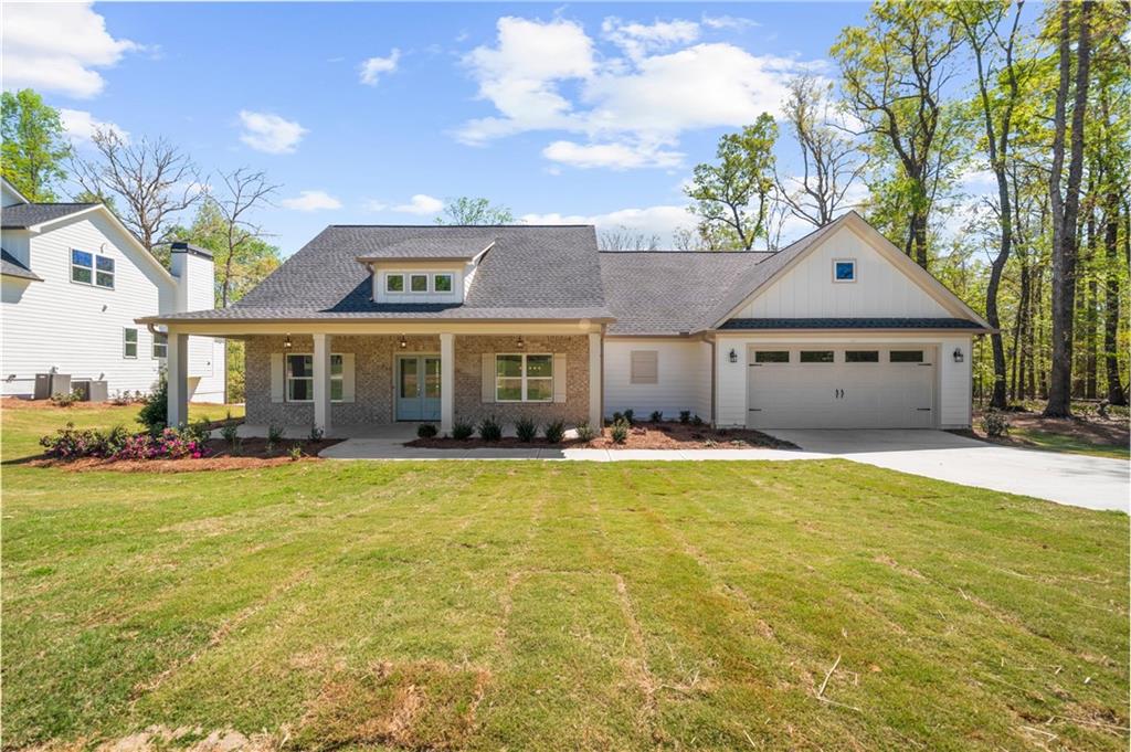 a front view of a house with swimming pool and porch with furniture