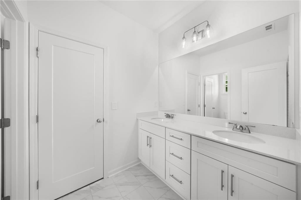 8915 Bethel Road Gainesville, GA 30506 - Photo 46 of 54 a spacious bathroom with a double vanity sink and a mirror