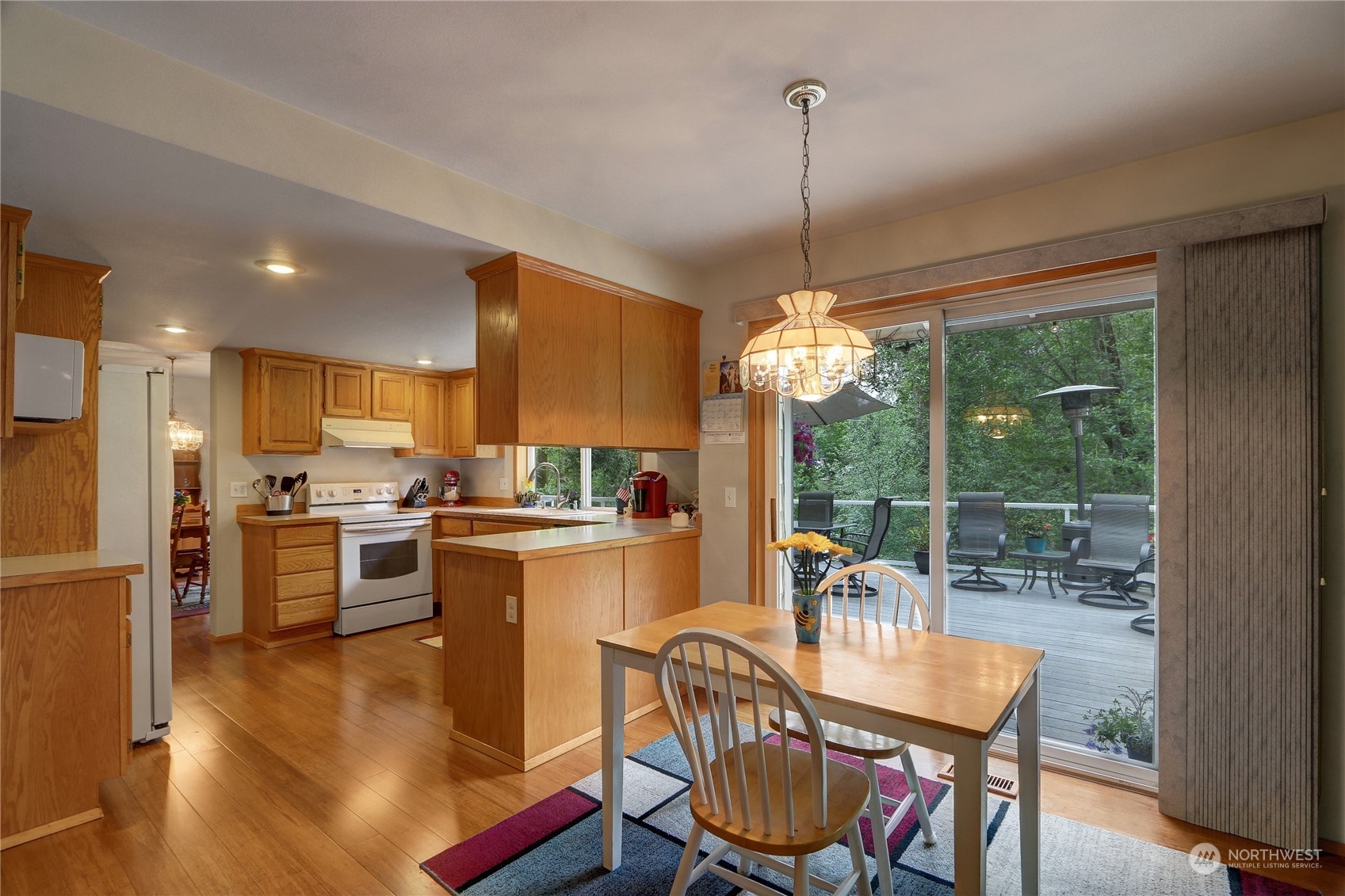 23113 Barker Road Bothell, WA 98021 - Photo 10 of 37 a dining room with furniture a chandelier and wooden floor